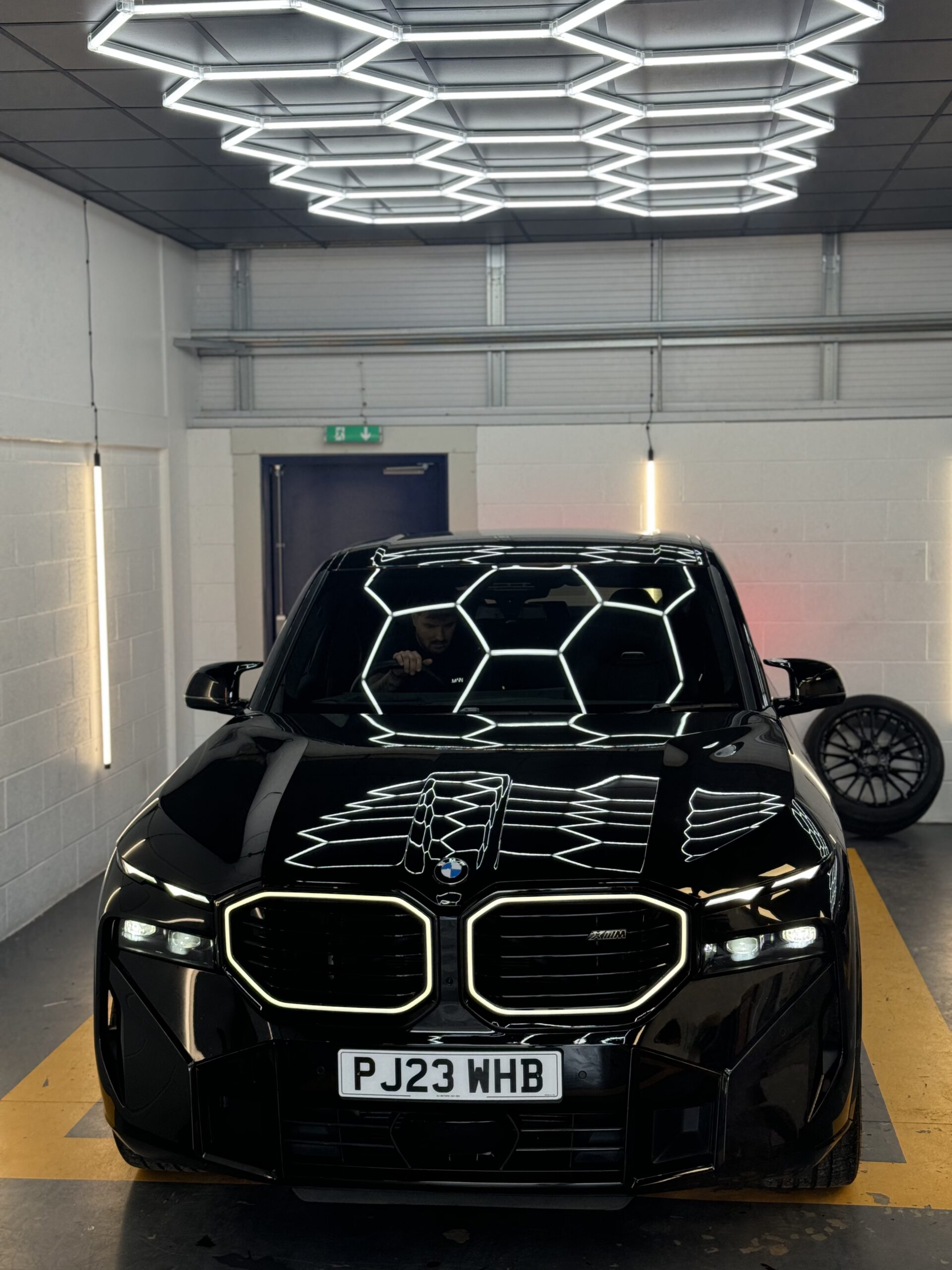Black BMW XM under the hexagon lights