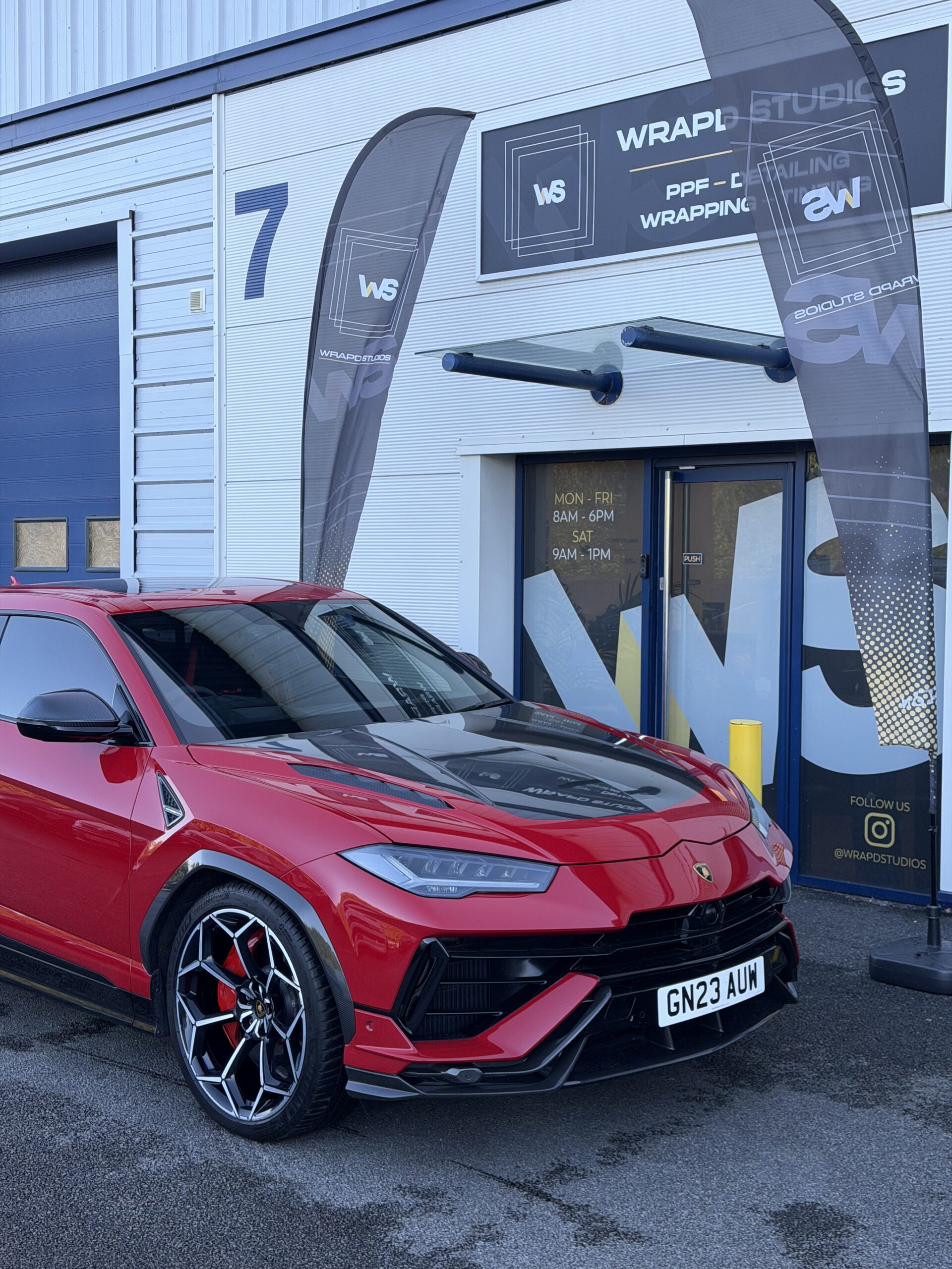 Red Lamborghini Urus with carbon body kit outside Wrapd Studios