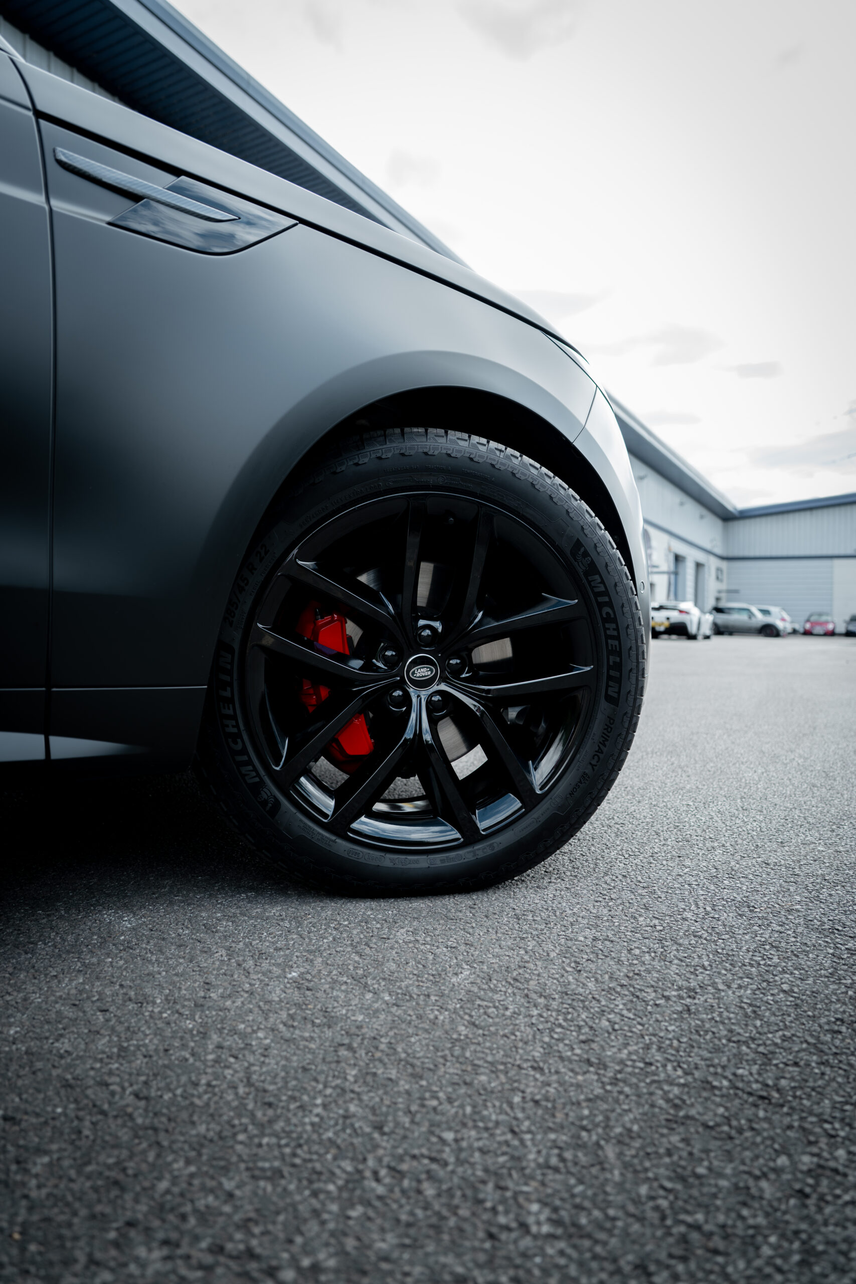 Black alloy wheel with red caliper, close-up