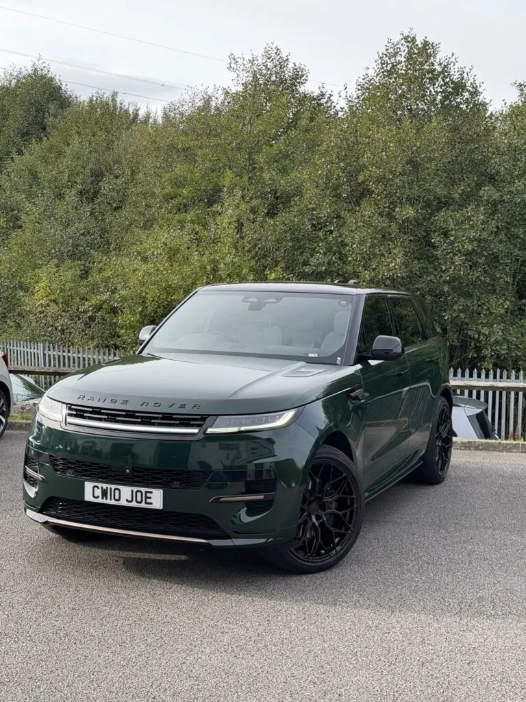 Dark green Range Rover Sport parked outdoors, front three-quarter view