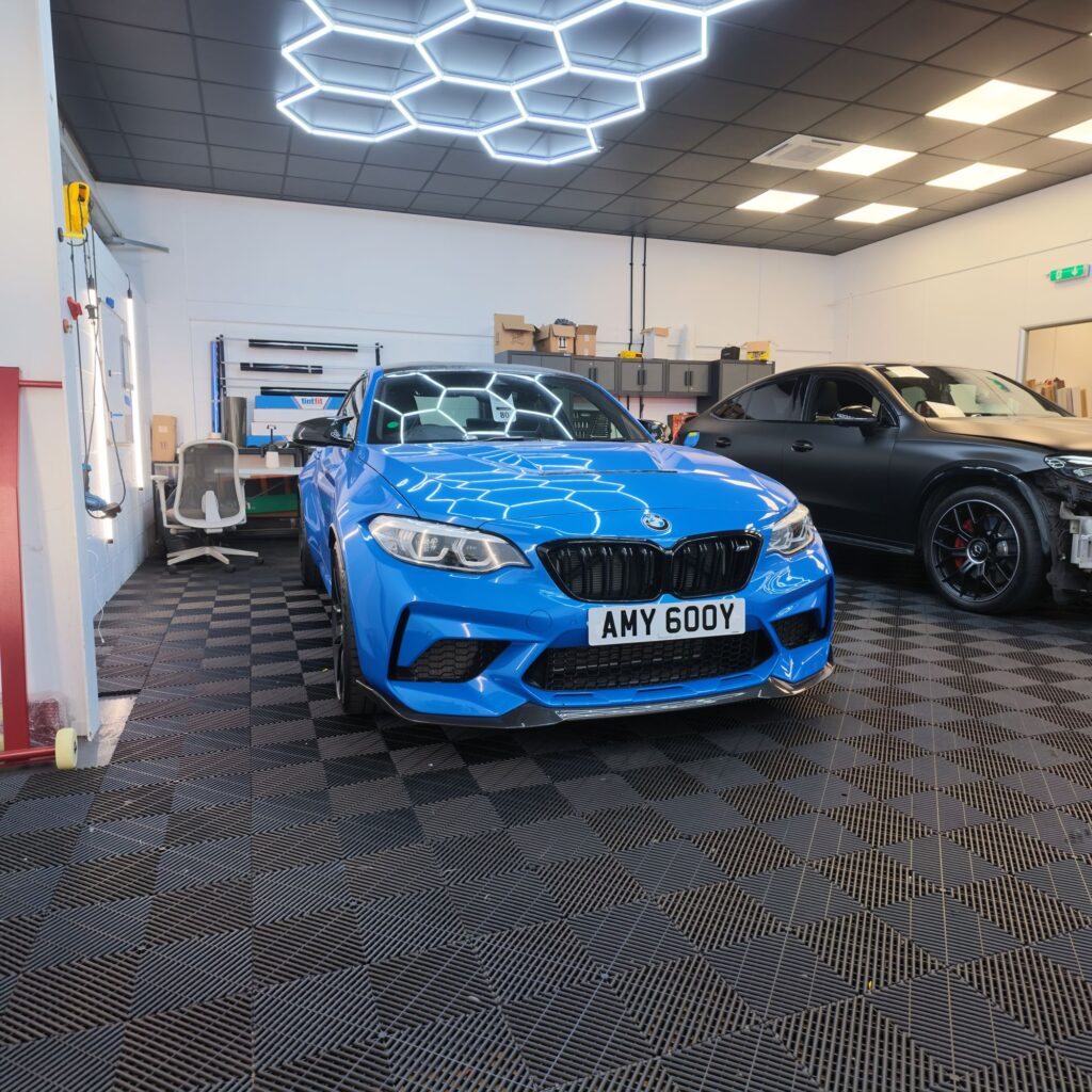 Blue BMW M2 under the hexagon lights at Wrapd Studios