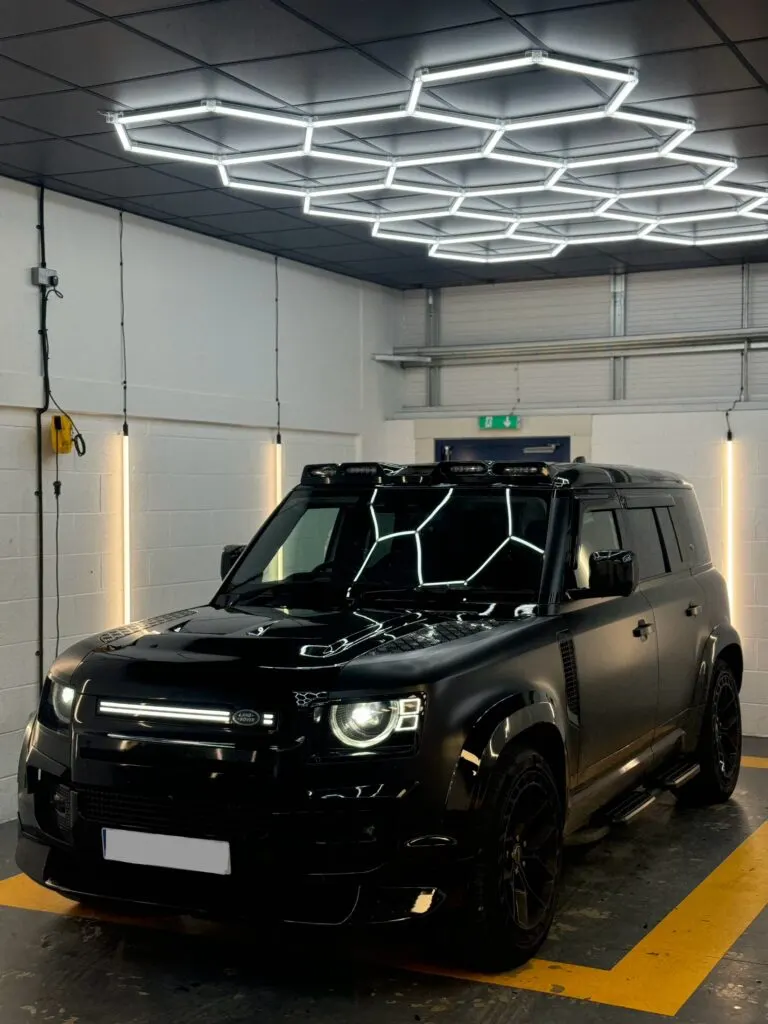 Black Land Rover Defender with roof light bar in the studio